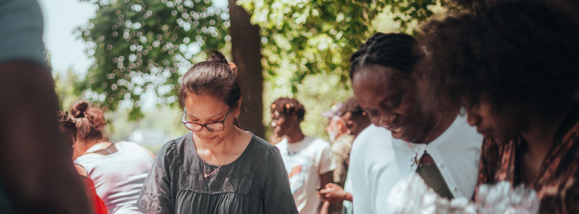 Parents serving food together at an outdoor gathering.